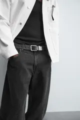 Pantalón de jean celeste con efecto lavado, corte holgado desde la cadera que se estrecha ligeramente en el bajo, tiro medio, cinco bolsillos y cierre frontal con cremallera y botón.