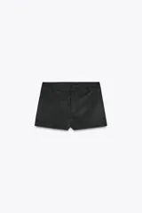 Shorts de tiro alto color negro con textura de gamuza, bolsillos delanteros y cierre frontal con cremallera y ganchos metálicos.