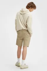 Bermuda color beige de corte chino, con bolsillos laterales y traseros.