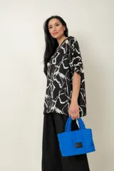 Cartera de tela color azul con asas torneadas y bolsillo interior, con opción de uso como bandolera.