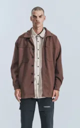 Chaqueta marrón de paño con cuello clásico, cierre frontal con botones, dos bolsillos de parche en el pecho y corte holgado.