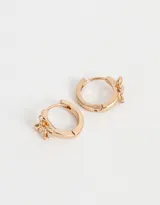 Aros tipo argolla bañados en oro rosa con dije de flor.