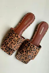 Zapato tipo slip on con estampado animal print en tonos tostados y detalles dorados.