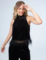 Conjunto de musculosa y pantalón en terciopelo negro, marca Julia Jordan. Blusa de cuello alto y terminación de ruedo con plumas. Pantalón con cintura elastizada.