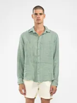 Camisa celeste de lino, de manga larga con botones de coco y parche de la marca.