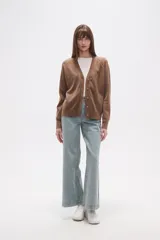 Cardigan de punto color blanco roto con motas oscuras, de manga larga y escote en V con cierre de botones frontales.