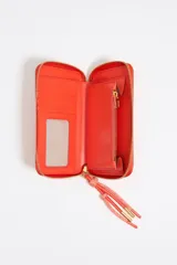 Billetera negra de piel reconstituida con estructura rígida, cierre con cremallera dorada, tirador de cordón y logo metálico Bimba y Lola. Cuenta con bolsillo interior con cremallera e interior con logo grabado.