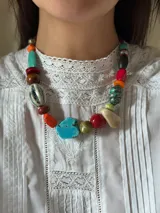 Collar corto con cuentas de cerámica, acrílico y piedras de colores. Se cierra con cadena de acero quirúrgico y ganchito para regular el largo.
