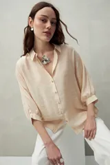 Camisa color crema de calce relajado con cuello clásico y mangas amplias tres cuartos.