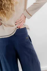 Pantalón sastrero azul marino de tiro alto, corte palazzo y bolsillos laterales.