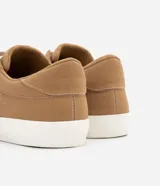 Championes urbanos de caña baja, color beige, con recortes y costuras contrastantes en blanco. Cierre con cordones y puntera redonda.