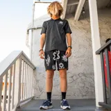 Bermuda negra con estampado de serpientes, soles y cactus en blanco. Confeccionada en poliéster reciclado REPREVE® con acabado DWR resistente al agua. Incluye bolsillos laterales, trasero con cierre YKK y lateral con cierre.