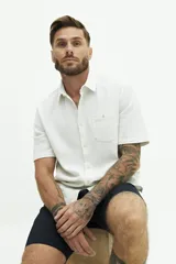 Camisa de manga corta blanca con textura tipo crepé y fit regular.