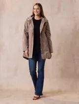 Campera impermeable color beige, marca Weatherproof, con capucha desmontable, cierre central oculto con botones a presión, bolsillos laterales con cierre y corte a la altura de la cadera.