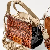 Cartera de cuero vacuno color whisky y negro, con manijas cortas y correa larga ajustable, diseño versátil.
