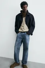 Pantalón de jean azul de corte recto, con cinco bolsillos, efecto lavado y cierre frontal con botones.