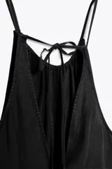Vestido midi negro de tejido fluido con cuello halter ajustable con lazada.