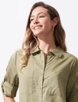 Camisa blanca de lyocell, marca Cyrus. Tiene cuello con solapa, abertura central con botones, mangas largas regulables con presilla y botón, y dos bolsillos delanteros aplicados.