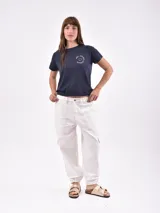 Pantalón jean náutico color blanco hueso, de corte recto, con bolsillos laterales tipo cargo y tobillos ajustados con elástico.