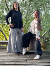 Remerón negro de manga larga, corte oversize con espalda más larga, tajos laterales y bajo redondeado.