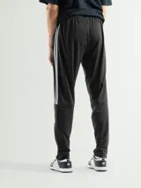 Pantalón deportivo gris de poliéster, ideal para actividades físicas, con diseño ajustado y detalles en los laterales.