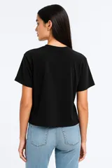 Remera negra de algodón con cuello redondo y estampado de corazones blancos.