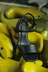 Sandalia de cuero negra con tira ancha sobre los dedos, pulsera con hebilla al tobillo y taco cuadrado.