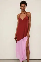 Vestido midi de seda color ladrillo y falda inferior color rosa, con breteles finos, escote en V y abertura lateral en la falda.