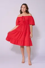 Vestido corto blanco con escote bardot, cintura fruncida y falda escalonada con vuelo.