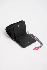 Billetera beige con diseño capitoneado y cierre de cremallera. Incluye cordón trenzado multicolor con terminales plásticas rosas.