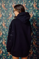 Buzo hoodie azul marino con lentejuelas plateadas y pequeños recortes en forma de corazón.
