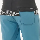 Short de baño Rip Curl Mirage Split Peak, con cintura negra, estampado geométrico en blanco y short azul.