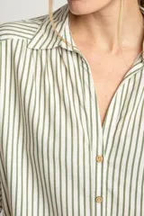 Camisa oversize a rayas verticales color verde y blanco, con cuello clásico, manga corta y cierre frontal con botones.