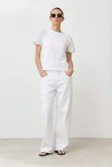 Remera blanca de algodón con mangas cortas de broderie. Corte recto y cuello redondo.