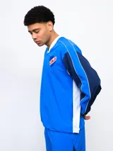 Buzo deportivo azul marino, rojo y blanco con escudo del Club Nacional de Football en el pecho y logo de Umbro en la manga.
