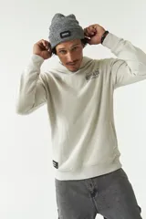 Canguro color gris claro con capucha, bolsillo tipo canguro y puños y cintura acanalados. Estampado con lettering en la espalda y detalle de bolsillo con botón en la manga.