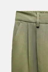Pantalón azul marino de tiro alto con bolsillos delanteros y terminación con vuelta en el ruedo. Cierre frontal con cremallera y botón.