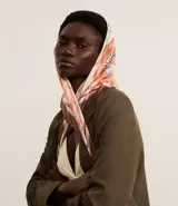 Pañuelo cuadrado de satén con estampado de motivos playeros en tonos rosados, marrones y blancos.