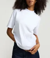 Remera gris de algodón con cuello alto y mangas cortas. Diseño cropped con nudo lateral.