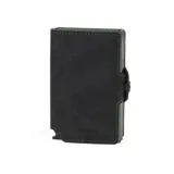 Billetera compacta de cuero negro con costuras verdes y mecanismo de eyección de tarjetas. Presenta el nombre "Baleine" grabado en la parte inferior frontal.