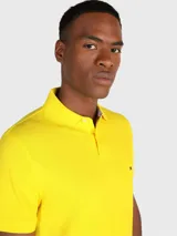 Chomba amarilla de Tommy Hilfiger, corte regular, con cuello tipo chomba, cartera de dos botones y logo bordado en el pecho.