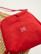 Bandolera azul de cuero gamuzado, con correa larga de soga azul y logo bordado en rojo.