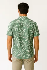 Camisa de viscosa con estampado de hojas de palmera en tonos azul y blanco, con cuello clásico y manga corta.