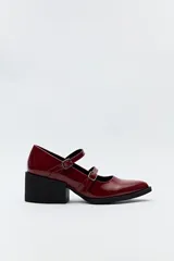Zuecos estilo Mary Jane color borgoña de charol, con doble tira con hebillas metálicas plateadas y taco bloque negro.