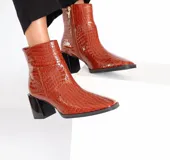 Botines de cuero color caramelo con textura croco, caña media, cierre lateral y tacón bloque negro de 7 cm.