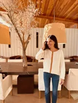 Sweater fino color crema con aplique vertical de cuero marrón en el centro.