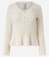 Blusa color crema de tejido de punto calado, con cuello en V, manga larga, cierre frontal con botones y volado en el bajo.