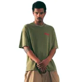 Remera verde con logo Kaboa estampado en rojo.