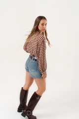 Minifalda de jean azul claro con corte evasé, detalle de short interno y cinturón negro con argollas metálicas.