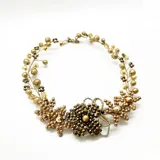 Collar dorado con diseño floral, elaborado con cuentas de diferentes tamaños y tonos de dorado.